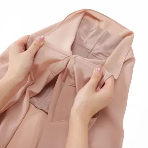 Detail view of pink chiffon hijab with magnetic buckle and inner cap, showing fine texture.