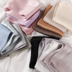 Close-up detail of smooth satin fabric folds in various vibrant colors, soft texture and sheen.