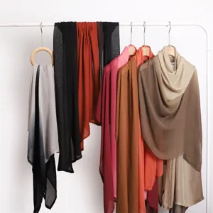 Vue détaillée de longs foulards en modal dégradé doux suspendus sur un portant, élégants.