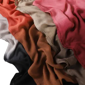 Gros plan détaillé d'une longue écharpe en modal dégradé douce, mettant en valeur les couleurs.