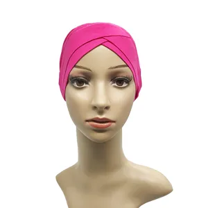 Close-up detail of the hot pink cross turban cap showing the soft modal fabric and pleated design.