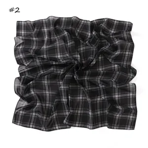 Black and white plaid chiffon square scarf detail, elegant draped pattern, soft fabric.