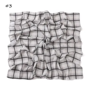 Detail shot of the black and white plaid chiffon square scarf featuring a chic swirl design.