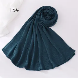 Dark green crinkle hijab detail view, lightweight polyester fabric texture, elegant drape.