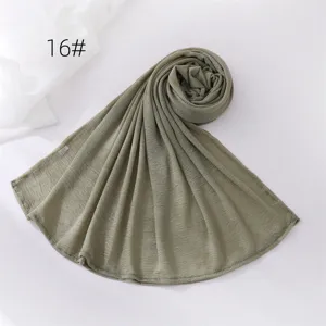 Green solid color wrinkled hijab scarf detail view, soft and breathable polyester fabric material.