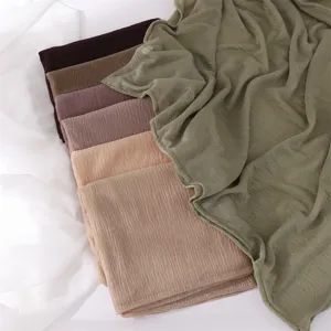 Close-up of soft crinkled polyester long scarf texture in multiple solid colors, breathable.