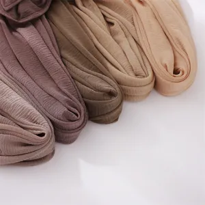 Close-up detail showing soft pleated texture and elastic polyester fabric of solid color scarf.