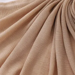 Detailed view of lightweight pleated khaki polyester hijab fabric showing soft crinkled texture.