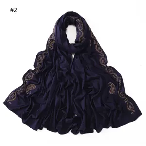 Detail view of dark blue mercerized cotton jersey scarf with sparkling rhinestone paisley patterns.