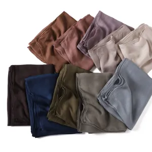 Detailed view of soft modal linen solid color scarves folded neatly in multiple gorgeous hues.