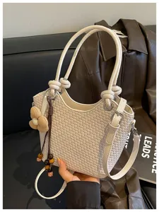 Chic sac seau tressé pour femmes, élégant sac à bandoulière avec charmant pendentif.
