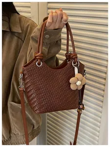 Sac seau tressé marron chic avec pendentif fleur, sac à main élégant pour femme détails.