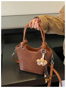 Sac seau tressé marron chic pour femme avec poignée élégante et joli pendentif floral.