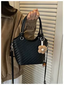 Sac seau tissé noir avec breloque fleurie, élégant sac à bandoulière pour femmes.