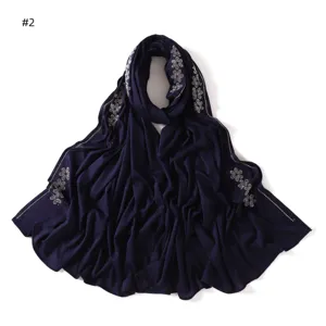 Detailed view of the dark blue jersey scarf featuring exquisite rhinestone flower patterns.