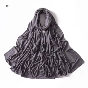 Solid color mercerized cotton jersey hijab scarf detail view showing rhinestone floral pattern.