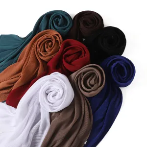 Detail close-up of pleated shimmering chiffon hijab scarf, soft breathable crinkled wrap.
