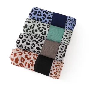 Detailed view of stacked women pleated scarves featuring trendy leopard print and solid color block.