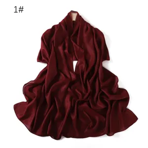 Dettaglio della sciarpa in chiffon lucido bordeaux, texture liscia e lucentezza.