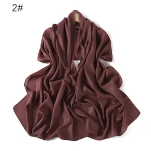 Vista dettagliata che mostra la tessitura del tessuto in chiffon perlescente lucido del foulard.
