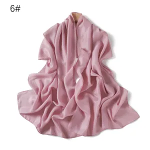 Vista dettagliata della sciarpa in chiffon rosa brillante, con tessuto lucido e drappeggio morbido.