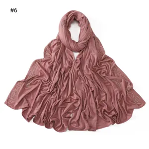 Rhinestone paisley detail on dusty pink modal hijab scarf, elegant edge decoration closeup.