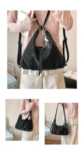 Vue détaillée du sac à dos hobo convertible noir polyvalent avec charmant pendentif étoile.