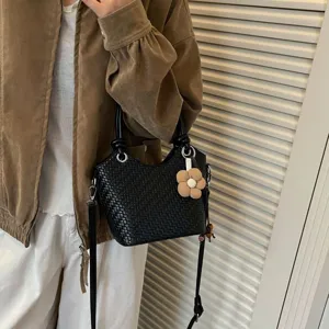 Sac seau tressé noir élégant pour femme, sac à bandoulière chic avec pendentif de fleur.