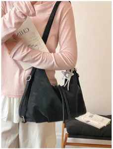 Détail du sac à dos convertible noir avec pendentif étoile argent et bretelles réglables.