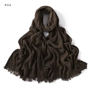 Detailed view of the dark brown wrinkled slub cotton scarf showing fine texture and fringe edge.