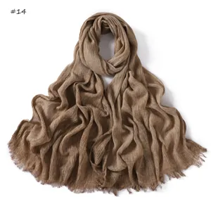 Solid color crinkled cotton scarf detail showing fine pleated texture and tassel fringe edges.