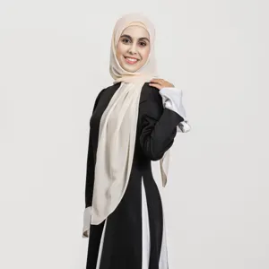 Détail de la robe noire élégante et du hijab crème portés par le mannequin avec grâce.