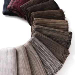 Close-up detail of soft crinkled cotton linen fringe scarves in various color options.