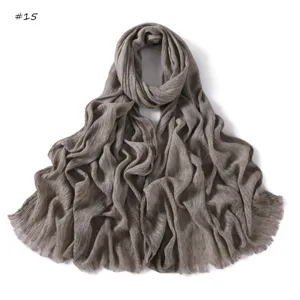 Close-up detail of soft crinkled slub cotton scarf with delicate fringe texture edge.