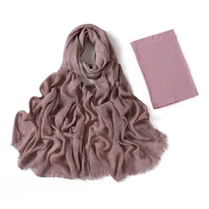 Dettaglio di sciarpa hijab stropicciata e cuffia tubolare abbinata, tessuto morbido, rosa antico.
