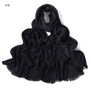 Detailed close-up view of dark pleated soft scarf showing fine folds and frayed edges texture.