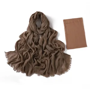 Sciarpa lunga stropicciata marrone abbinata a set di cuffie tubolari elastiche in rayon.