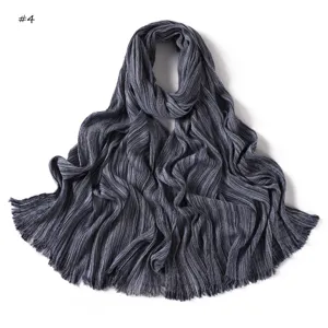 Detailed view of dark grey striped crinkled scarf texture, soft fringe edge fabric.