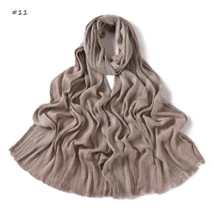 Detail view of a soft pleated fringe long scarf shawl in khaki, textured crinkle design.