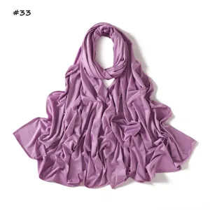 Primer plano del pañuelo suave de jersey morado, con textura lisa y una elegante caída.