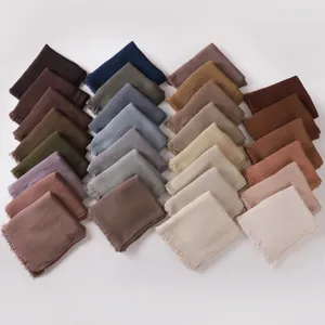 Detailed view of soft crinkled modal solid color long scarfs with fringe in various shades.