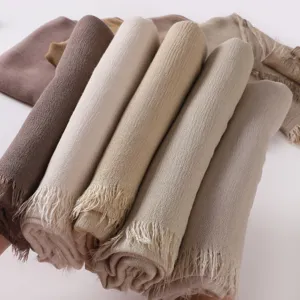 Detailed view of rolled multi-color wrinkled long scarves with fringe edge for women.