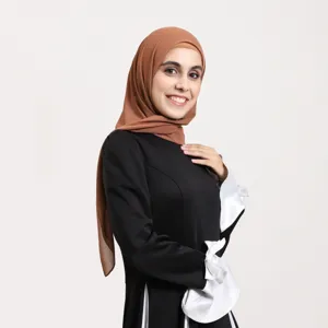 Detail shot of Muslim dress featuring black long sleeves, elegant white flare cuffs, and brown hijab.