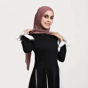 Detailed view of women elegant black dress with white cuffs and matching mauve chiffon hijab headscarf.