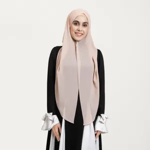 Close-up detail of the elegant beige chiffon hijab and black-white dress ensemble in studio view.