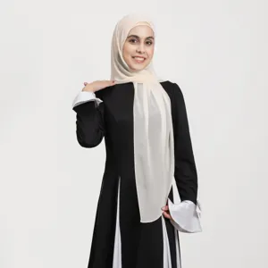 Close-up detail of stylish black and white long dress with matching elegant hijab scarf.