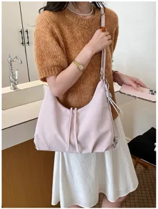 Vue détaillée du sac à dos et sac à bandoulière convertible élégant pour femme en rose.