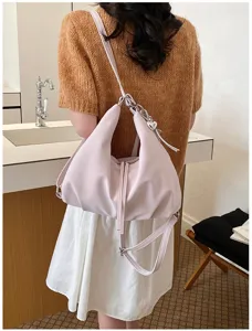 Vue détaillée élégante du sac à dos et sac à bandoulière rose multifonctionnel pour femme.