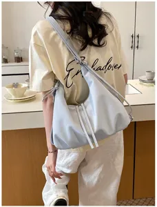 Vue détaillée d'un sac bandoulière hobo bleu clair élégant au design souple et aux lanières chics.