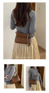Vue détaillée du sac à épaule marron tressé avec de charmants pendentifs rétro élégants.